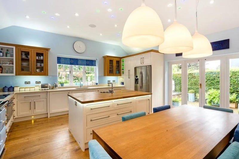 The open plan kitchen and dining room has underfloor infrared heating. It has also been fitted with handpainted wood cabinets, a wood topped central island and quartz-style composite surfaces. There is a Miele double oven, a fully-restored gas-fired Aga, a bespoke cooker hood with integrated lighting and a bespoke glass splashback. Picture: Savills - Haywards Heath.