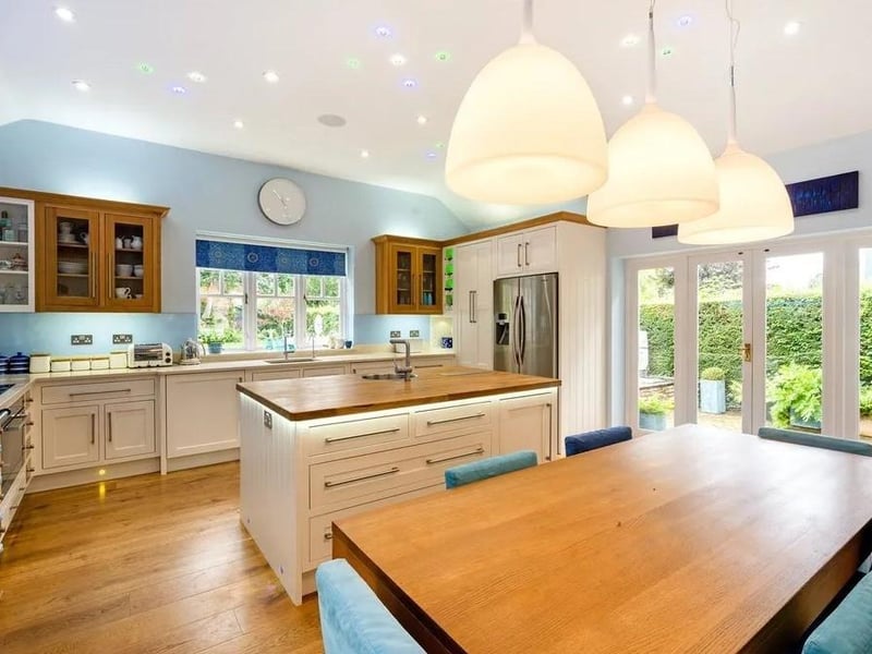 The open plan kitchen and dining room has underfloor infrared heating. It has also been fitted with handpainted wood cabinets, a wood topped central island and quartz-style composite surfaces. There is a Miele double oven, a fully-restored gas-fired Aga, a bespoke cooker hood with integrated lighting and a bespoke glass splashback. Picture: Savills - Haywards Heath.
