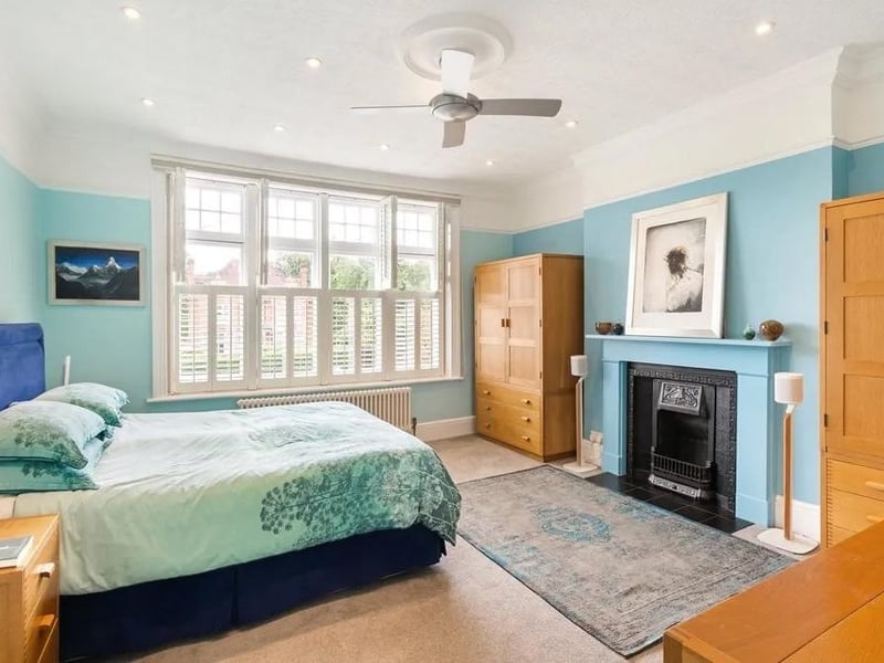 The principal bedroom has a ceiling fan, LED recessed ceiling lights, and an en suite shower room with underfloor heating. Picture: Savills - Haywards Heath.