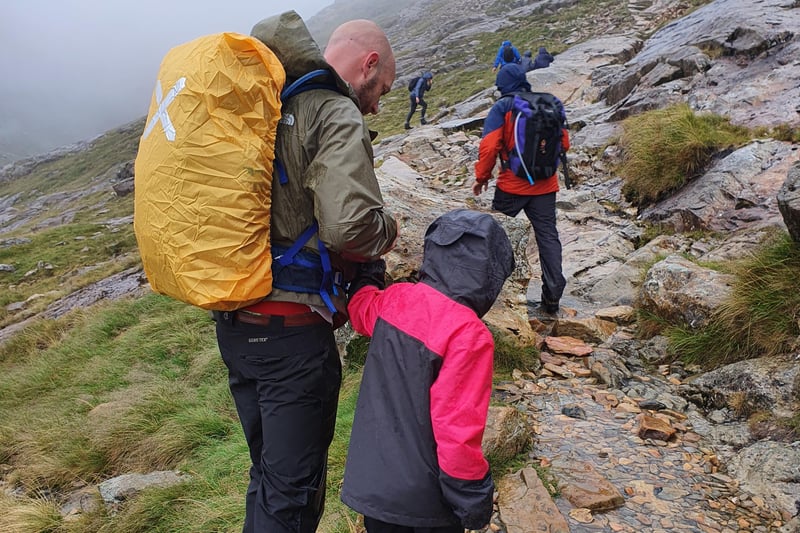 Paige, and her dad Mark, making their way up the slippery rocks of Mount Snowdon on their trek for the Guide Dogs charity