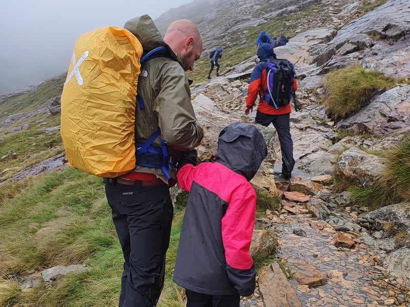 Paige, and her dad Mark, making their way up the slippery rocks of Mount Snowdon on their trek for the Guide Dogs charity