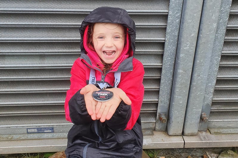 Paige smiling with her 'Snowdon trek' medal after reaching the top of the mountain