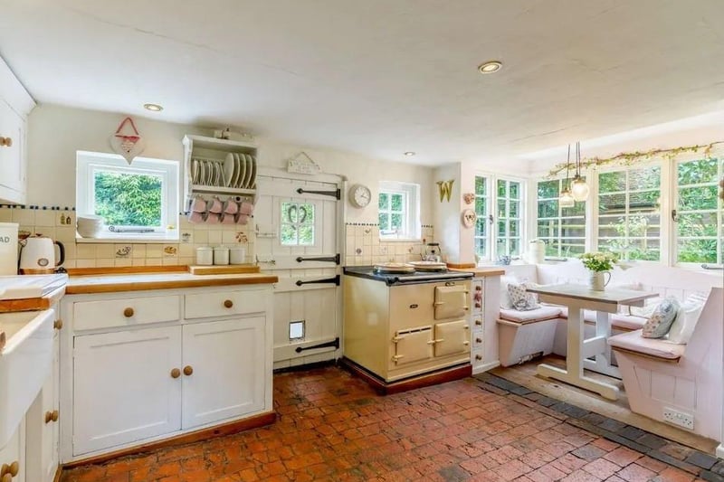 The country style kitchen has triple aspect views, an Aga and a box bay window with fitted seating. Picture: Strutt & Parker - Horsham.