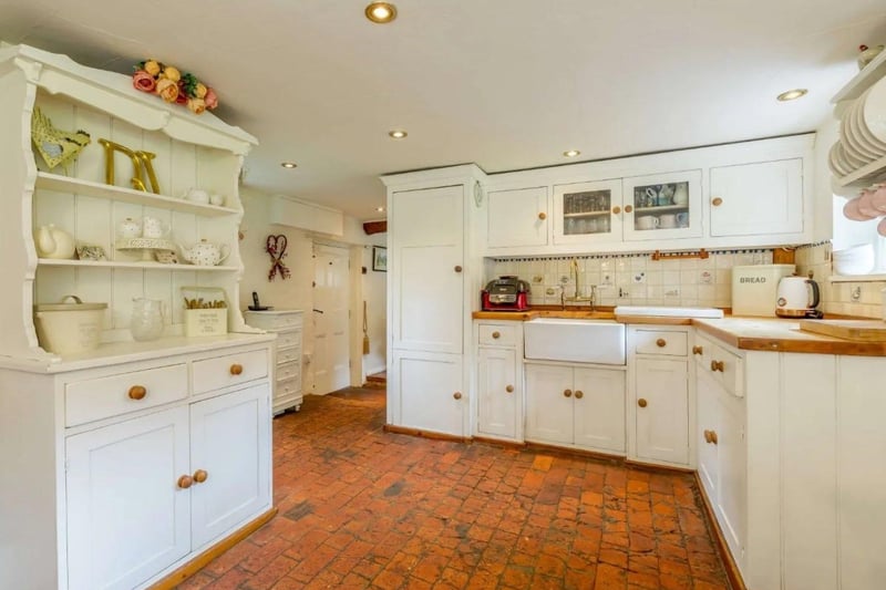 The house features a bespoke fitted kitchen with red brick flooring. Picture: Strutt & Parker - Horsham.