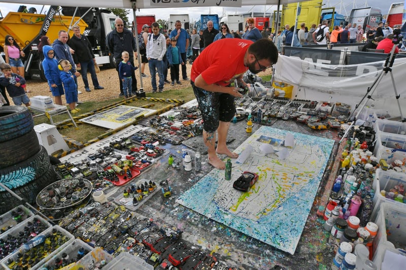 Truckfest 2021 at the East of England Arena.   Artist Ian Cook who uses model cars to paint with EMN-210829-170619009
