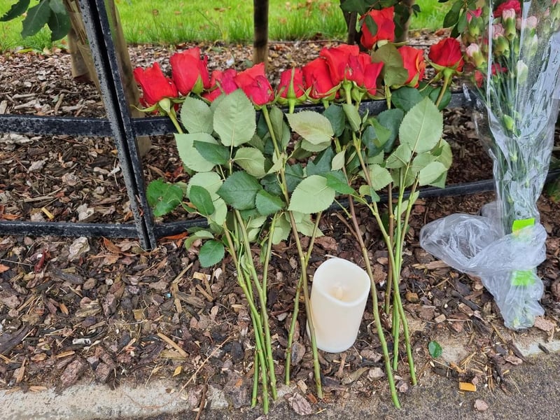 A dozen red roses have been left at the scene