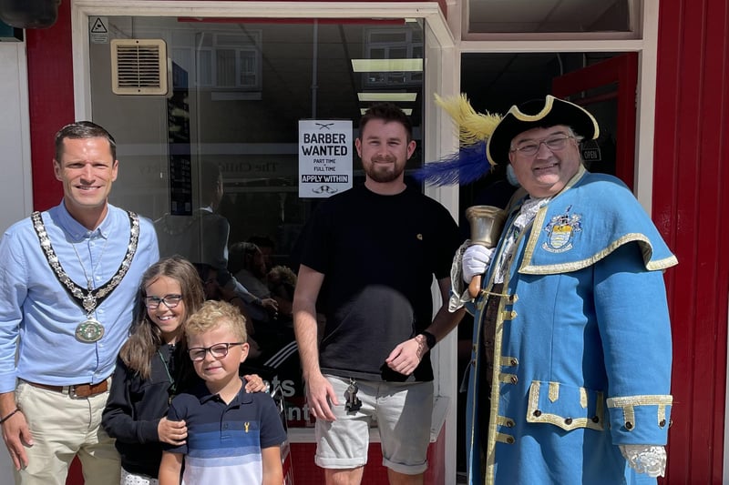 Stephen Chipp, chairman of Adur District Council with his children and Bob Smytherman, Worthing town crier, outside the Barbers on Southwick Sqaure, Southwick