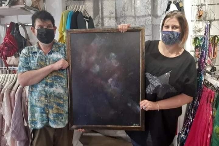Cosmic art by Stephen Pratt, pictured with event supporter Sarah McCrossan, of Daisy B's.