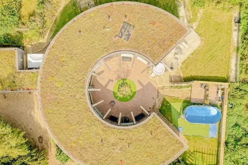 This aerial view shows the unique design of the building and the paddling pool on the property.