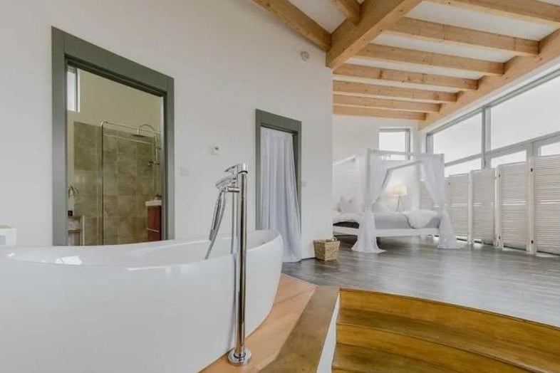 The luxurious bath, en-suite shower and master bed, all in one photo.
