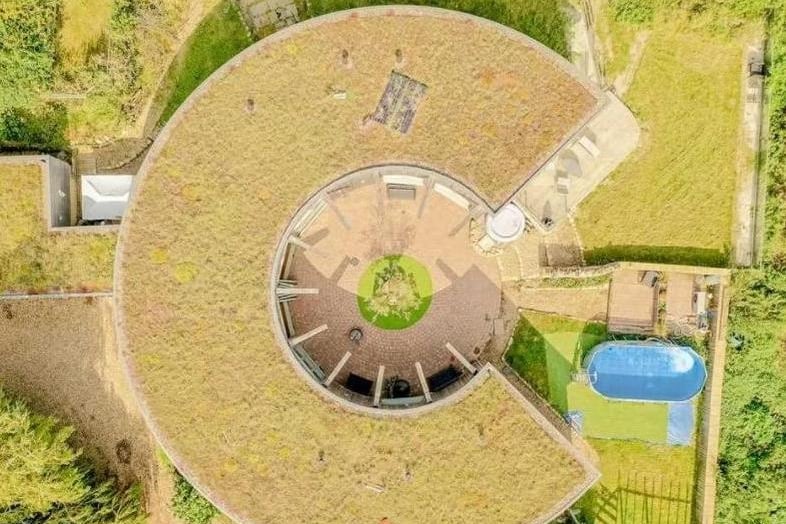 This aerial view shows the unique design of the building and the paddling pool on the property