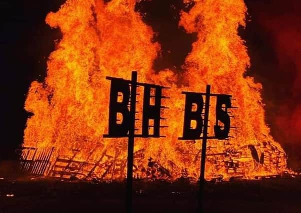 Burgess Hill Bonfire Society's initials silhouetted against the flames. SUS-210928-133737001