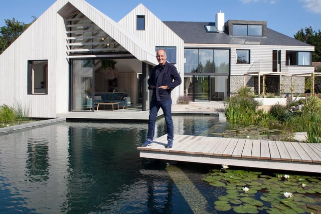 Presenter Kevin McCloud outside the property with natural pond.