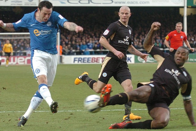 Posh star Lee Tomlin challenged by Leicester City skipper Wes Morgan in 2013.
