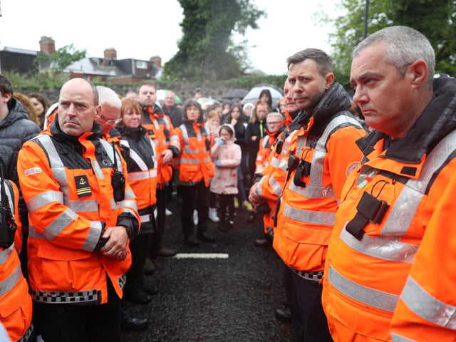 Volunteers from the Community Rescue Service form a guard of honour during the vigil.