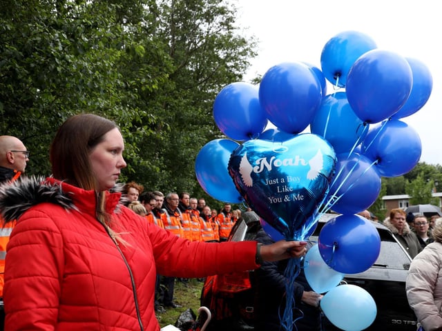 Noah's family and friends ready 14 balloons before releasing them during the vigil.