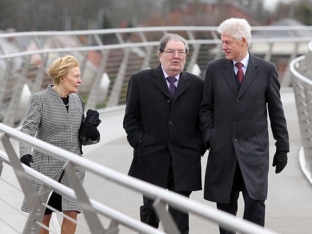 Pat Hume with her husband and former SDLP leader John Hume and Bill Clinton walk across the Peace Bridge.