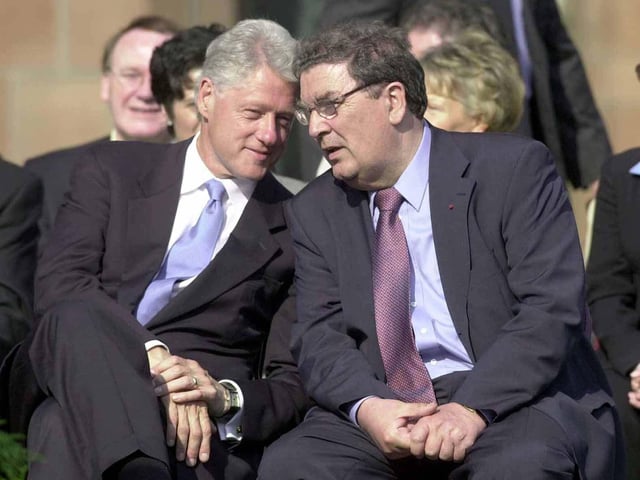 Former U.S. President Bill Clinton shares a quiet word with John Hume before his address in the Guildhall Square, during his visit to Northern Ireland.
