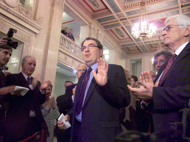 John Hume is applauded by colleagues in the Great Hall of Stormont, Dublin, after he announced his resignation as leader of the SDLP
