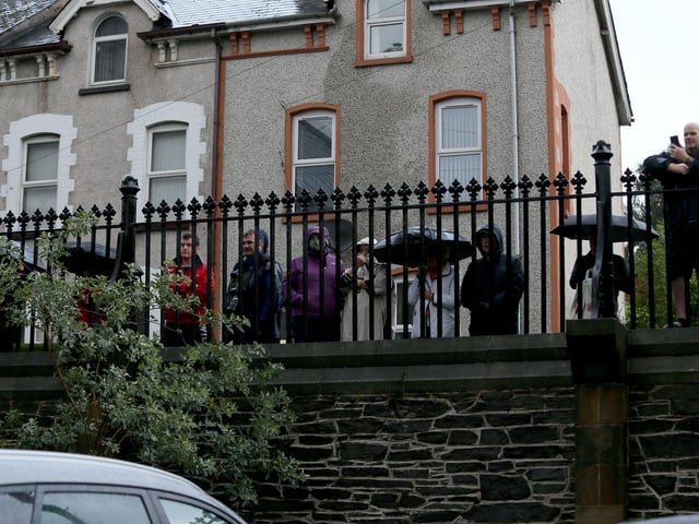 Socially distanced mourners lined the driveway of the church with candles