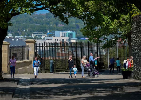People maintain social distancing while exercising on Derry Walls