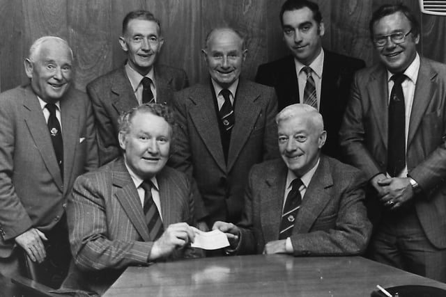 Mr George Perry, seated right, secretary of the Linfield Souvenir Shop, presenting a £1,000 cheque to Dr Larry Warke, Linfield chairman, at a ceremony in the club’s boardroom in September 1980. Included are Richard Murdie, left, treasurer of the souvenir shop, William Bell, centre, chairman of the shop and David Crawford, honorary treasurer of Linfield. Picture: News Letter archives