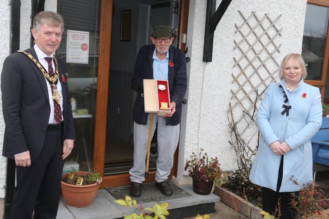 Royal Navy Able Seaman Thomas Clarence receives his silver Poppy of Remembrance from the Mayor of Causeway Coast and Glens Borough Council Alderman Mark Fielding and Veterans’ Champion Councillor Michelle Knight McQuillan