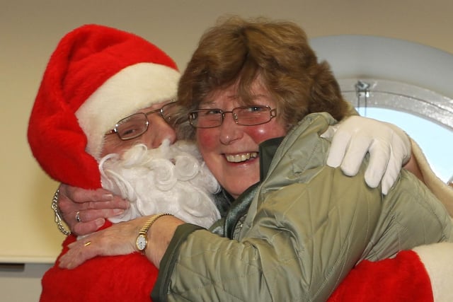 Gracehill After Schools Club Volunteer Davina Smiley gets a special hug from Santa during his visit to children and staff last week