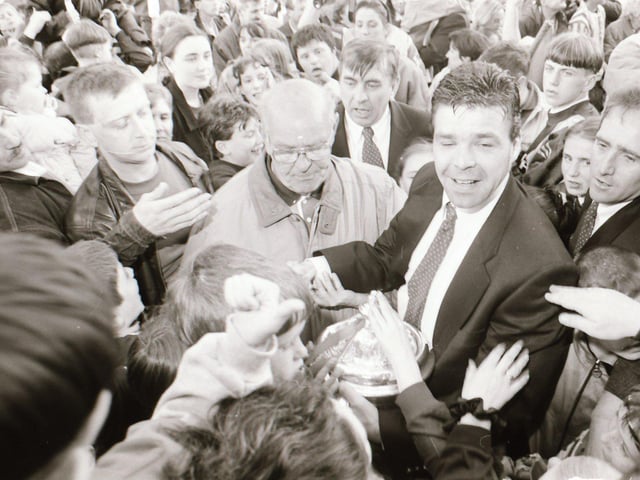 Derry City goalkeeper Dermot O'Neill makes his way through the large crowd with the FAI Cup in hand as the players are greeted in Guildhall Square.