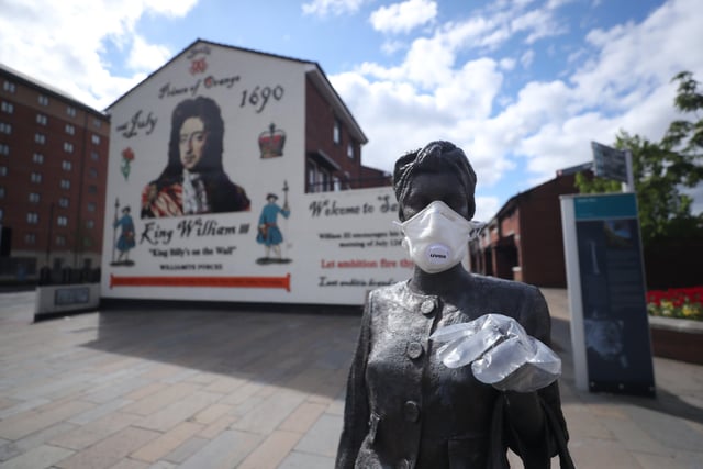 A statue by artist Ross Wilson entitled Mother Daughter Sister, celebrating female identity and culture, in Sandy Row Belfast is adorned with a mask and disposable gloves as the UK heads towards a seventh week in lockdown to try and limit the spread of coronavirus.