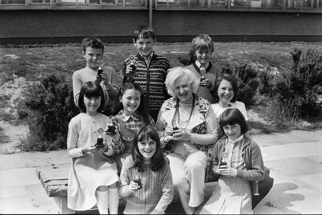 1977... Mary Guckian, principal, Holy Child PS, presenting trophies to the winners of the school's junior youth club competitions. Front, from left, Ursula Deeney, Majella McKeever, Jacqueline O'Kane, Cathy Patterson, Tina Gillespie. At back, Jim Nash, Kevin Doherty and Thomas McManus.