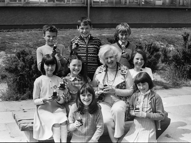 1977... Mary Guckian, principal, Holy Child PS, presenting trophies to the winners of the school's junior youth club competitions. Front, from left, Ursula Deeney, Majella McKeever, Jacqueline O'Kane, Cathy Patterson, Tina Gillespie. At back, Jim Nash, Kevin Doherty and Thomas McManus.
