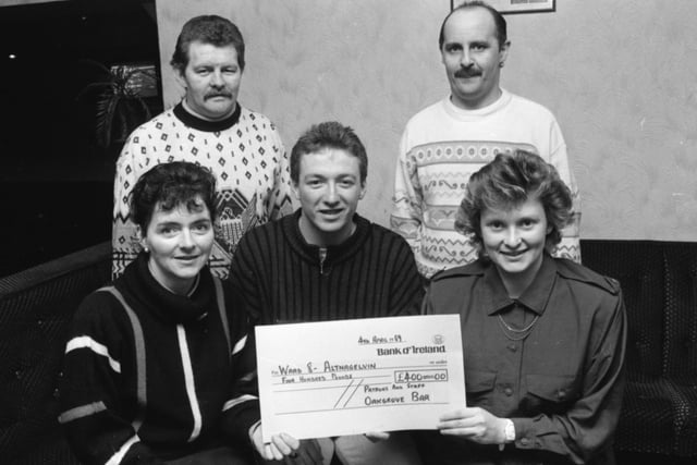 Derry City FC striker Liam Coyle presents a cheque for £400, on behalf of the staff and patrons of the Oak Grove Bar, Bishop Street, for the Ward 8 Patients’ Comforts’ Fund, to Staff Nurses Anne Doherty (on left) and Rosemary Bond. At back are Danny Melly, on left, and Gerry McGowan, organisers of a charity evening in the bar.