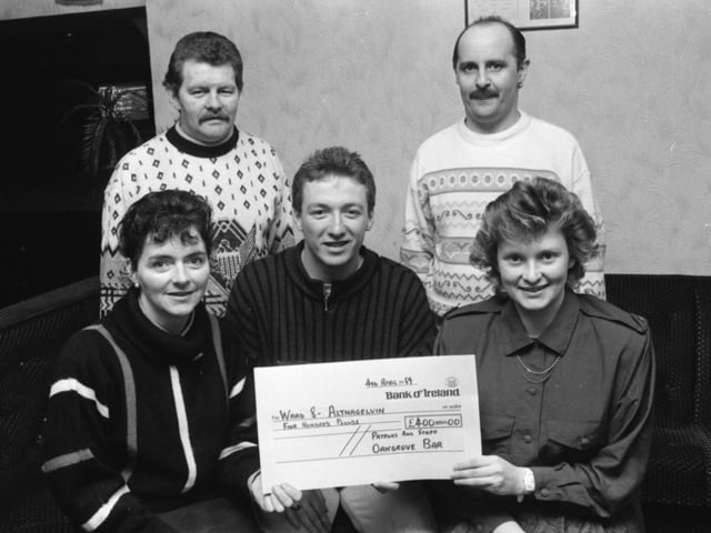 Derry City FC striker Liam Coyle presents a cheque for £400, on behalf of the staff and patrons of the Oak Grove Bar, Bishop Street, for the Ward 8 Patients’ Comforts’ Fund, to Staff Nurses Anne Doherty (on left) and Rosemary Bond. At back are Danny Melly, on left, and Gerry McGowan, organisers of a charity evening in the bar.