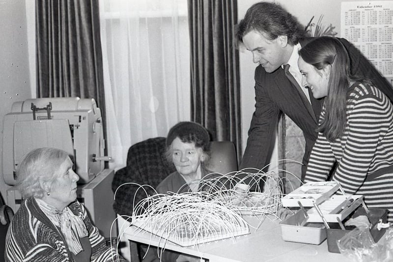 Health Minister John Patten toured social services units in east Belfast at the end of January 1982. Mrs Mary Crooke, above left, sang him a song at her Beechbank House for visually and hearing impaired. Joining in are Mrs Minnie Flanagan and craft instructor Jane Garvey. Picture: News Letter archives