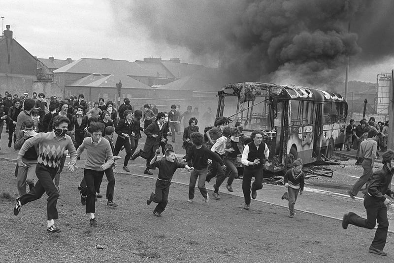 PACEMAKER PRESS INTL. BELFAST. Youths in Derry's Bogside as vehicles burn in the background during a protest during the Apprentice Boys March. 12/8/80.'