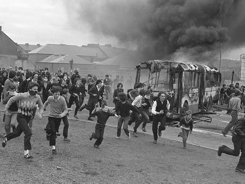 PACEMAKER PRESS INTL. BELFAST. Youths in Derry's Bogside as vehicles burn in the background during a protest during the Apprentice Boys March. 12/8/80.'
