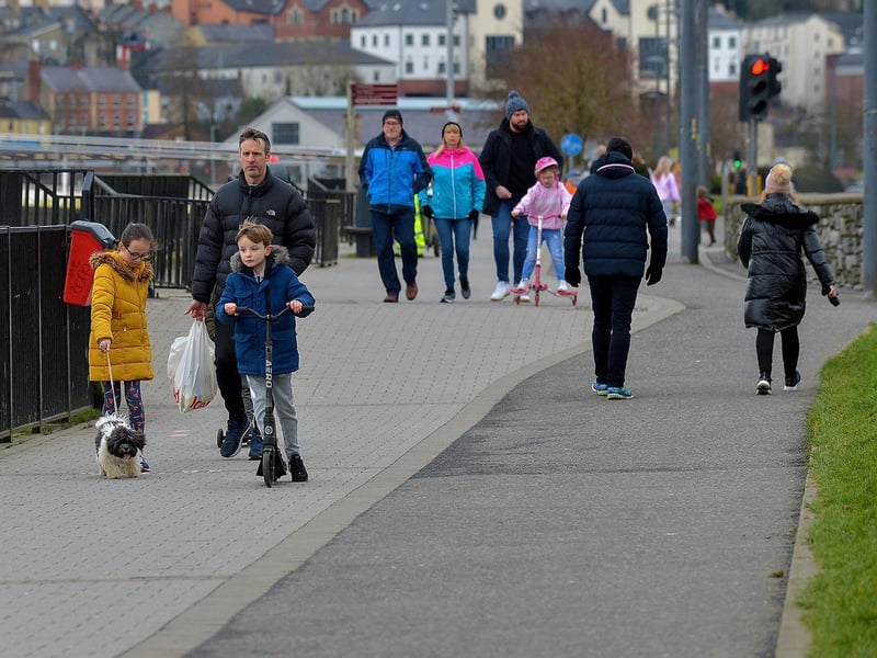 People enjoy a walk along the riverfront recently. DER2106GS – 006