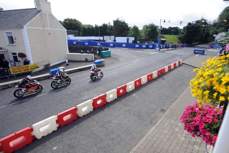 A Dunlop family portrait as Michael leads Sam and William into the hairpin in Armoy village at the start of the 125cc race.