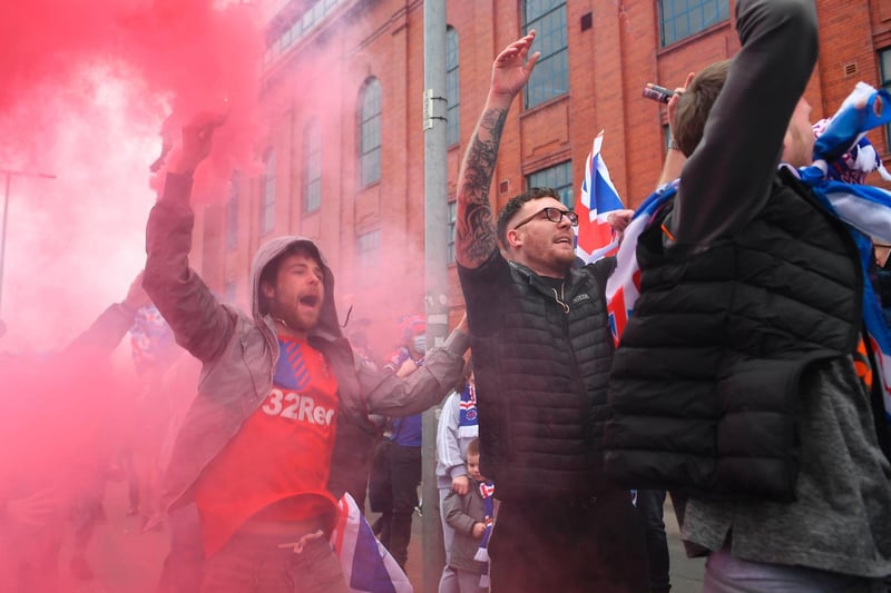 Rangers fans celebrate with flags and smoke grenades outside Ibrox Stadium