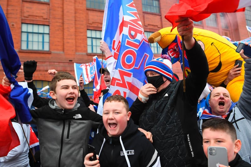 Rangers fans celebrate with flags outside Ibrox Stadium