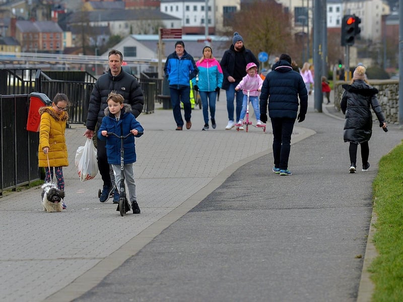 People enjoy a walk along the riverfront recently. DER2106GS – 006