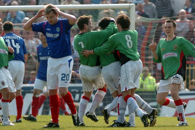 Linfield's Stuart King has his head in his hands as the Glentoran players celebrate Stephen Parkhouse's opener