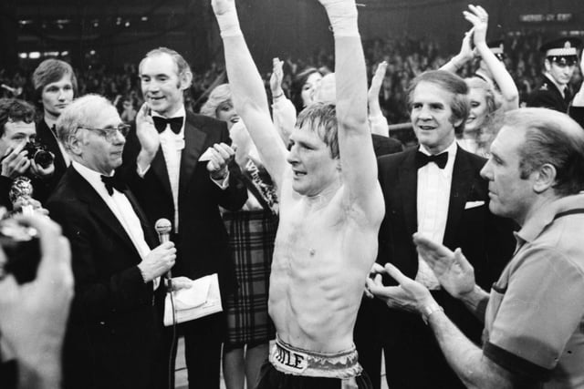 A triumphant Jim Watt salutes the crowd in the Kelvin Hall following his victory.