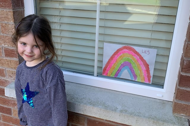 Lily with her rainbow she painted standing outside our house