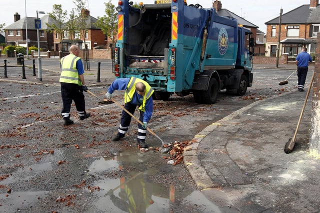 Debris is cleared after a night of rioting in Ardoyne in north Belfast