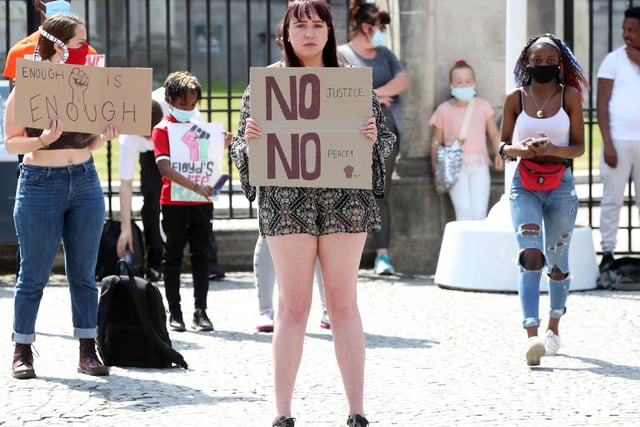 'No justice, no peace' reads a placard held by a young woman at the Black Live Matter solidarity rally in Belfast on Monday.