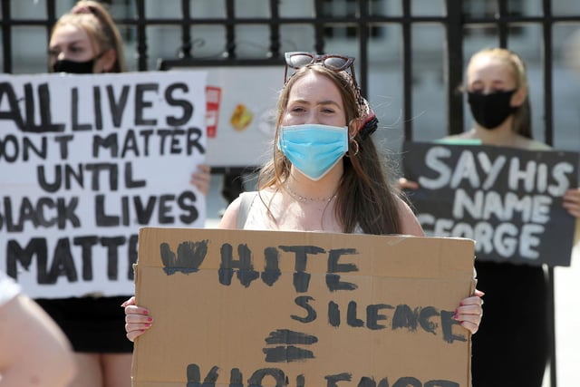 'White silence is violence' reads a placard held by one young woman at the rally.