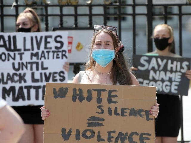 'White silence is violence' reads a placard held by one young woman at the rally.