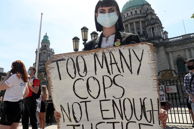 'Too many cops, not enough justice' reads a placard at the solidarity rally in Belfast on Monday.